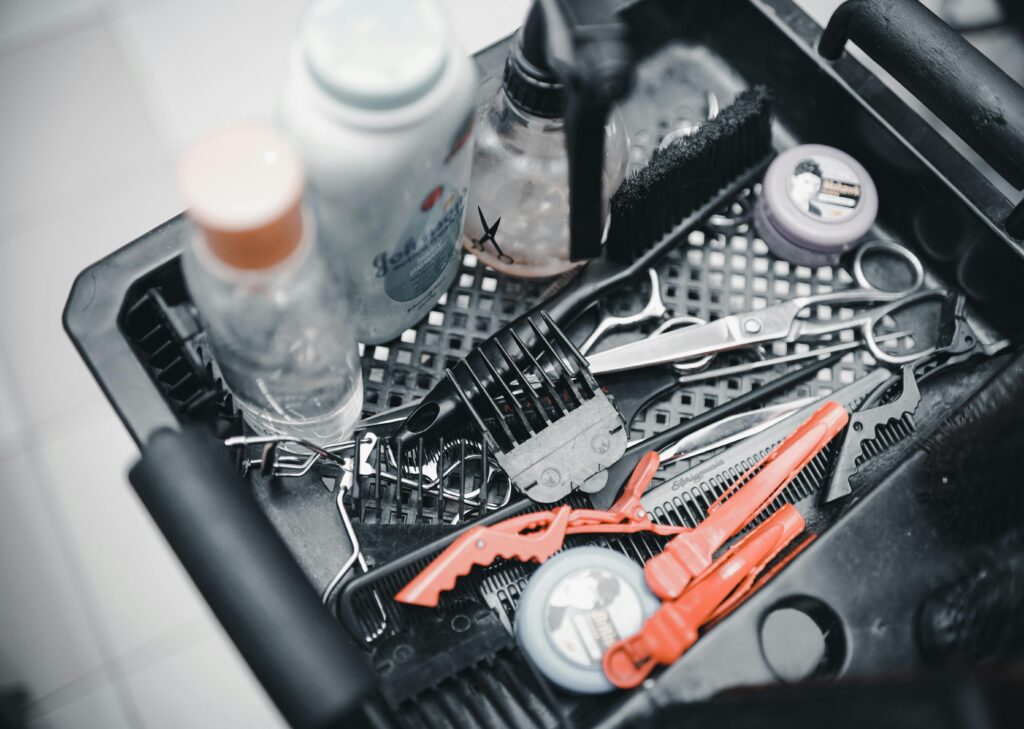 Close-up of hairdressing tools in a salon setting, featuring scissors, combs, and styling products.